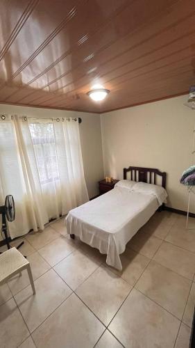 een slaapkamer met een bed en een houten plafond bij Casa morfo in Bijagua