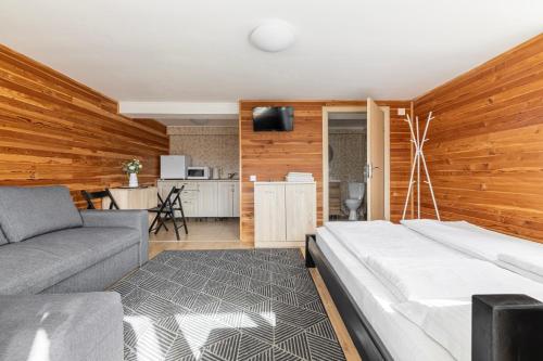 1 dormitorio con cama, sofá y cocina en Woodvel House en Palyanytsya