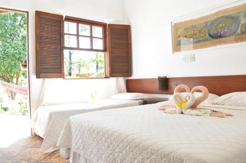 - une chambre avec 2 lits avec 2 animaux rembourrés sur le lit dans l'établissement Pousada Nova Papa Terra, à Itacaré