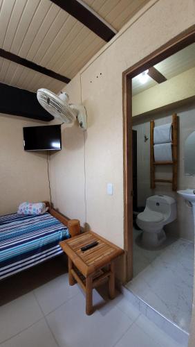 1 dormitorio con 1 cama, aseo y mesa en Hotel Mansur, en La Tebaida