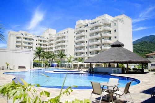 ein Hotel mit einem Pool und einem Gebäude in der Unterkunft Porto Marina Itacuruça Mangaratiba in Mangaratiba