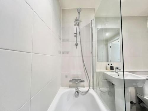 a white bathroom with a tub and a sink at Short term apartment in London in London