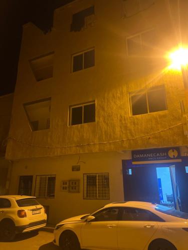 dois carros estacionados em frente a um edifício à noite em appartements meublée nr 1 en rez-de-chaussée em Oujda