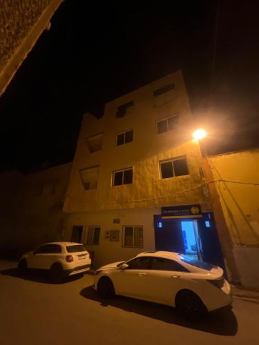 un coche blanco estacionado frente a un edificio por la noche en appartements meublée nr 1 en rez-de-chaussée, en Oujda