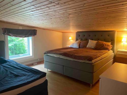 1 dormitorio con 1 cama con techo de madera en Centralt boende, pool, nära till natur & våtmark en Eskilstuna