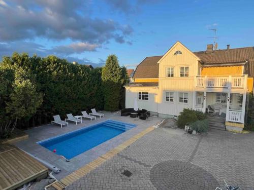 una casa con piscina al lado de una casa en Centralt boende, pool, nära till natur & våtmark en Eskilstuna