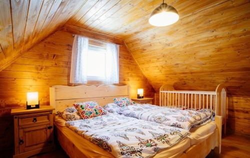 a bedroom with a bed in a wooden cabin at DREVENÁ CHALÚPKA in Šumiac