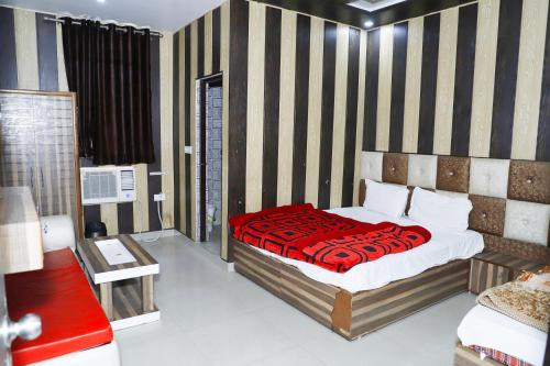 a bedroom with a bed with a red blanket at Hotel elibrista in Meerut