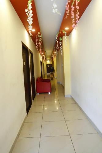 a hallway with a red couch in a building at Hotel elibrista in Meerut