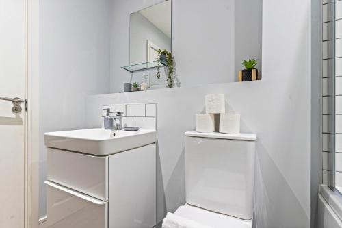 een witte badkamer met een wastafel en een spiegel bij Vibrant Bliss - Vibrant 2BED 2BATH Birmingham in Birmingham