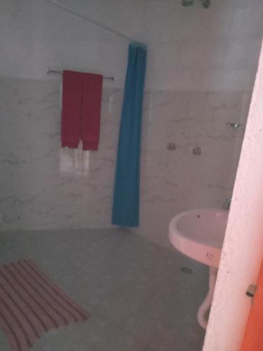- Baño con toalla roja y lavamanos en Departamento el Javi, en Camotepec