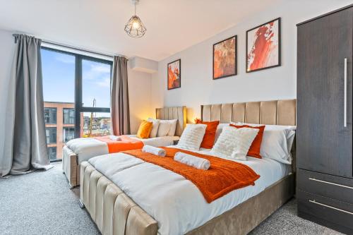 2 bedden met oranje en witte kussens in een slaapkamer bij Vibrant Bliss - Vibrant 2BED 2BATH Birmingham in Birmingham