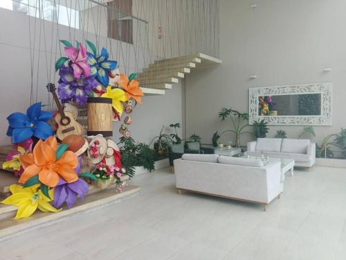 ein Wohnzimmer mit Sofa und Blumen an der Wand in der Unterkunft Hermoso apartamento, moderno, club house, excelente ubicación!, in Neiva