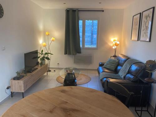 sala de estar con sofá y mesa en Gîte avec spa, en Saint-Avit-Sénieur