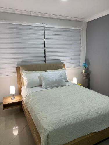 a bedroom with a large bed with white sheets and pillows at apartamento en manga in Cartagena de Indias
