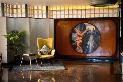 a living room with a chair and a mirror at Hotel Torremolinos Vallejo Ciudad de Mexico in Mexico City