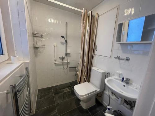 a white bathroom with a toilet and a sink at Norland House in London