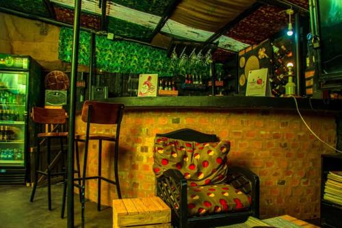 een bar met een stoel voor een bakstenen muur bij Naalya Motel in Kampala