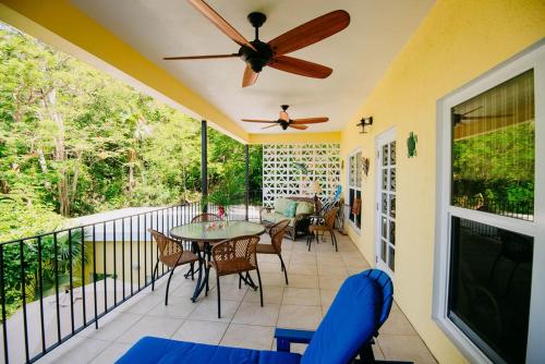a porch with a ceiling fan and a table and chairs at Fiesta in Enighed
