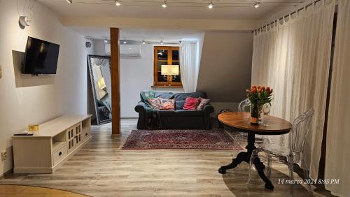 ein Wohnzimmer mit einem Sofa und einem Tisch in der Unterkunft Apartament Singera in Biłgoraj