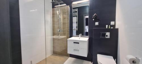 a bathroom with a toilet and a sink and a shower at Metro Modern Warsaw Apartments in Warsaw