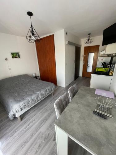 une chambre avec un lit et une table dedans dans l'établissement Studio curistes ou vacances à 300 m des Thermes, à Balaruc-les-Bains