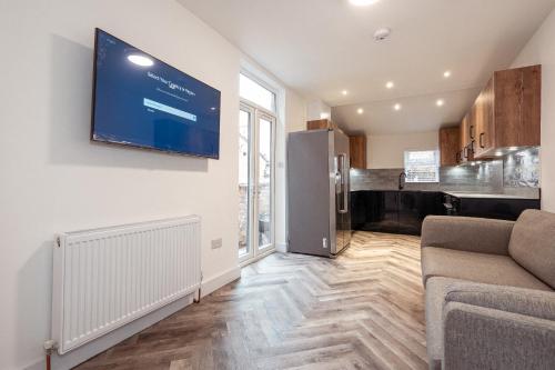 曼徹斯特的住宿－Ashley’s Place，客厅配有沙发和墙上的电视