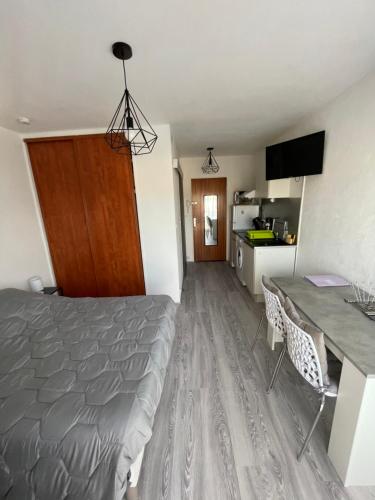 une chambre avec un lit et une table et une cuisine dans l'établissement Studio curistes ou vacances à 300 m des Thermes, à Balaruc-les-Bains