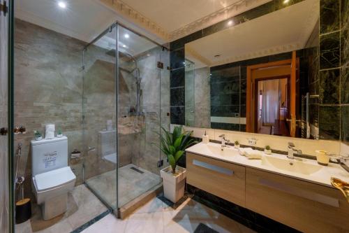 y baño con ducha, aseo y lavamanos. en Appartement Haut Standing Gueliz Plaza avec Vue en Marrakech