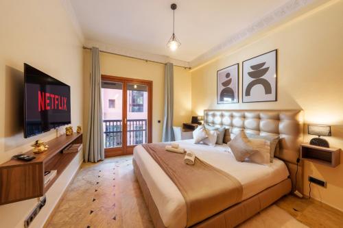 Appartement Haut Standing Gueliz Plaza avec Vue في مراكش: غرفة نوم بسرير كبير وتلفزيون