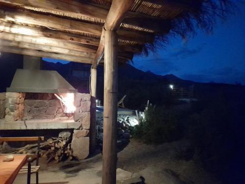 a patio with an outdoor fireplace at night at Bendita Piedra Suites, Las Compuertas Lujan de Cuyo in Ciudad Lujan de Cuyo