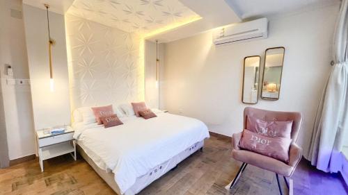 a bedroom with a white bed and a chair at شالية ديور الفندقي in Al Wudayy