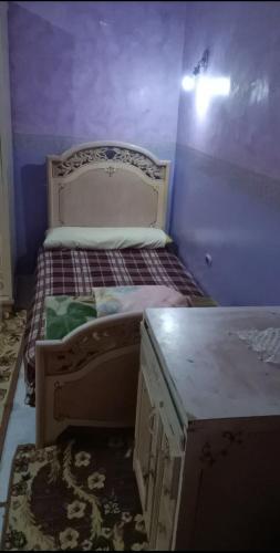 a bedroom with a bed with purple walls at Ema in Cairo