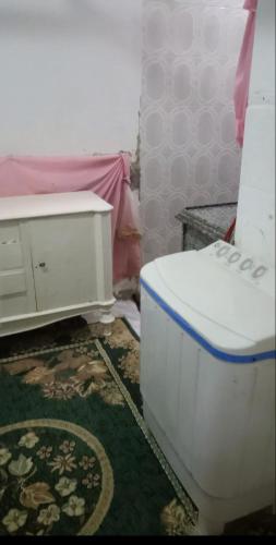 a bathroom with a toilet and a dresser at Ema in Cairo