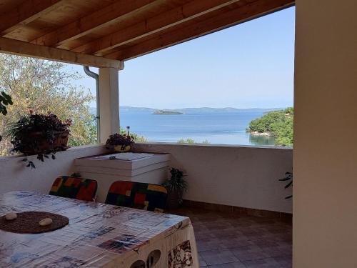 a porch with a table and a view of the water at Apartments by the sea Sali, Dugi otok - 8117 in Sali