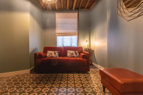 a living room with a red couch and a window at Au temps suspendu in Marche-en-Famenne