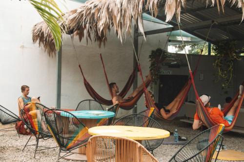 a group of people sitting in hammocks under an umbrella at Casa Wolaba in Puerto Limón