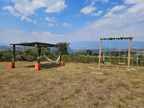 a swing set on top of a field at Zona de Camping El mirador in Villa de Leyva