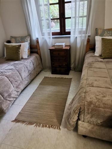 a living room with two beds and a window at Quinta Souto da Ordem - House in Castelo Novo