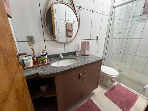 uma casa de banho com um lavatório, um espelho e um WC. em Loft 05 Excelente Localização em Cuiabá