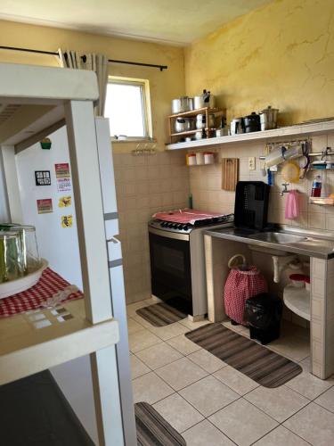 a small kitchen with a stove and a refrigerator at Apartamento Aluguel Morro Branco. in Beberibe