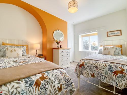 1 dormitorio con 2 camas y espejo en Middle Farm Cottage en Avebury