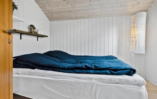 a bed with a blue blanket in a room at Awesome Home In Føllenslev With Wifi in Føllenslev
