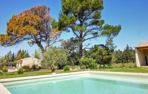 ein Swimmingpool vor einem Haus mit Bäumen in der Unterkunft Le Cabanon in Maussane-les-Alpilles