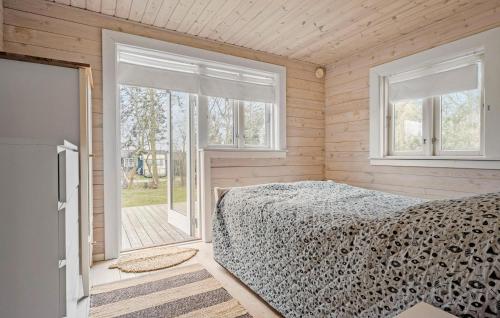 ein Schlafzimmer mit einem Bett in einem Zimmer mit Fenstern in der Unterkunft Cozy Home In Holbk With House Sea View in Holbæk