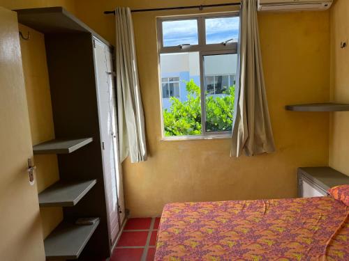 1 dormitorio con cama y ventana en Apartamento Aluguel Morro Branco., en Beberibe