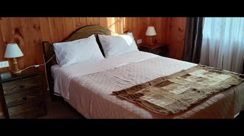 a bedroom with a large bed with white sheets and pillows at Cabaña de descanso in Las Cruces