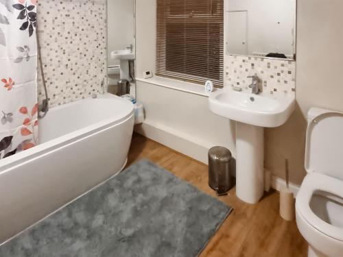 a bathroom with a tub sink and a toilet at Colin Grove Retreat in Brigham