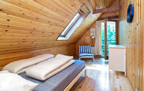 1 dormitorio con 1 cama con pared de madera en Stunning Home In Frederiksvrk With Wifi, en Frederiksværk