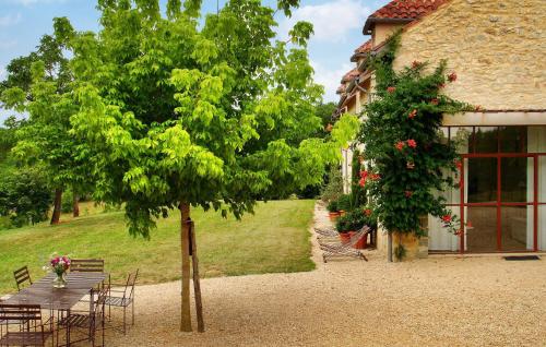une table et un arbre à côté d'un bâtiment dans l'établissement Lescalparède, à Florimont-Gaumiers